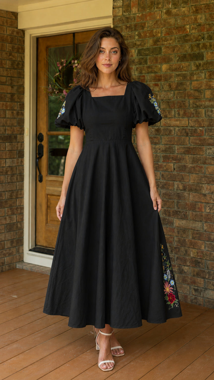 Front view of woman wearing black embroidered puff sleeve midi dress