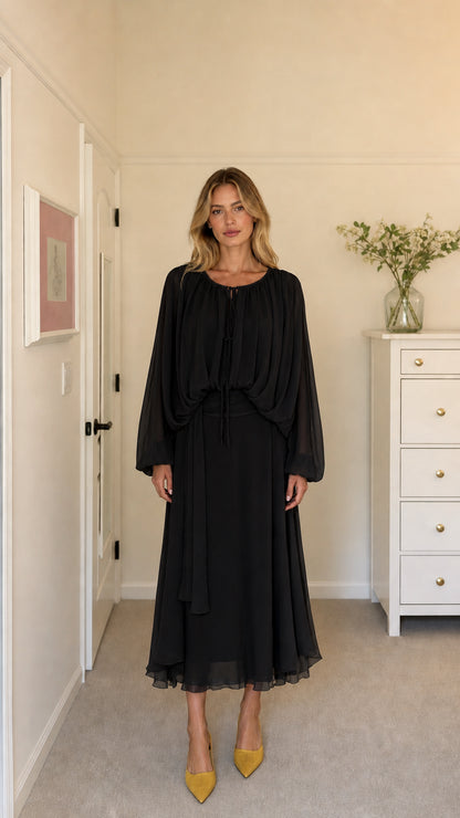 Model wearing black long-sleeve pleated midi dress
