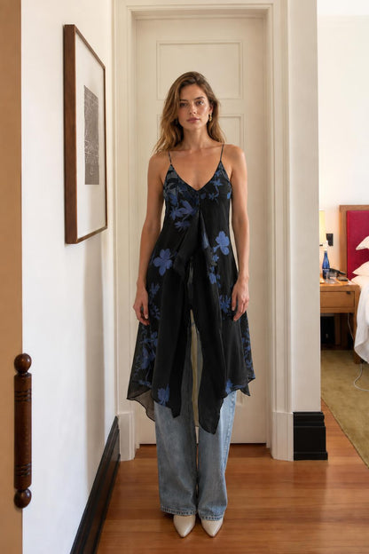 Model wearing black floral cami dress over denim
