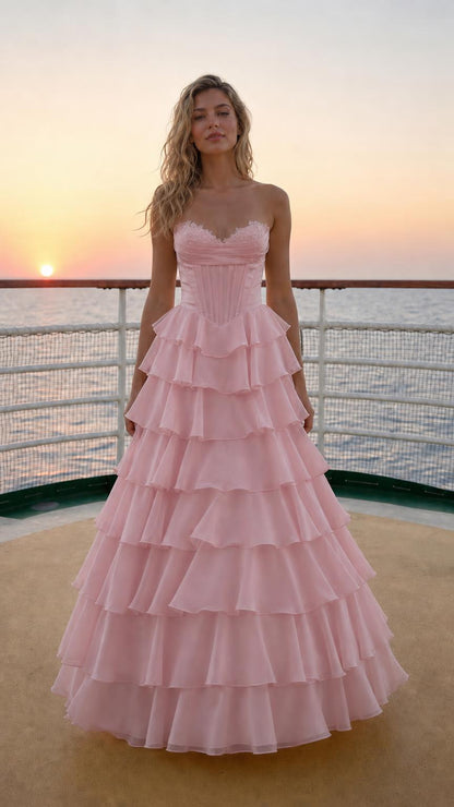 Model wearing pink sweetheart corset tiered ruffle long evening gown