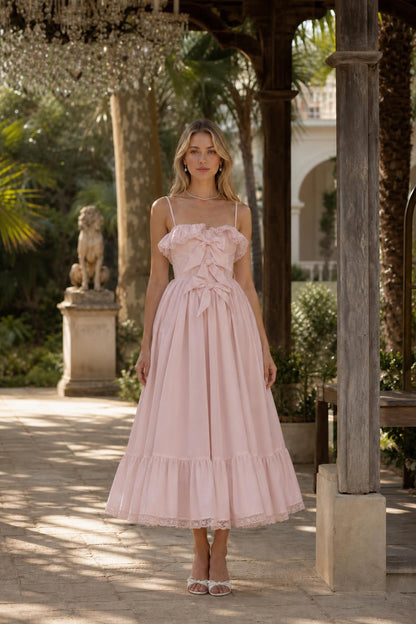 Front view of woman wearing pink bow accent midi dress