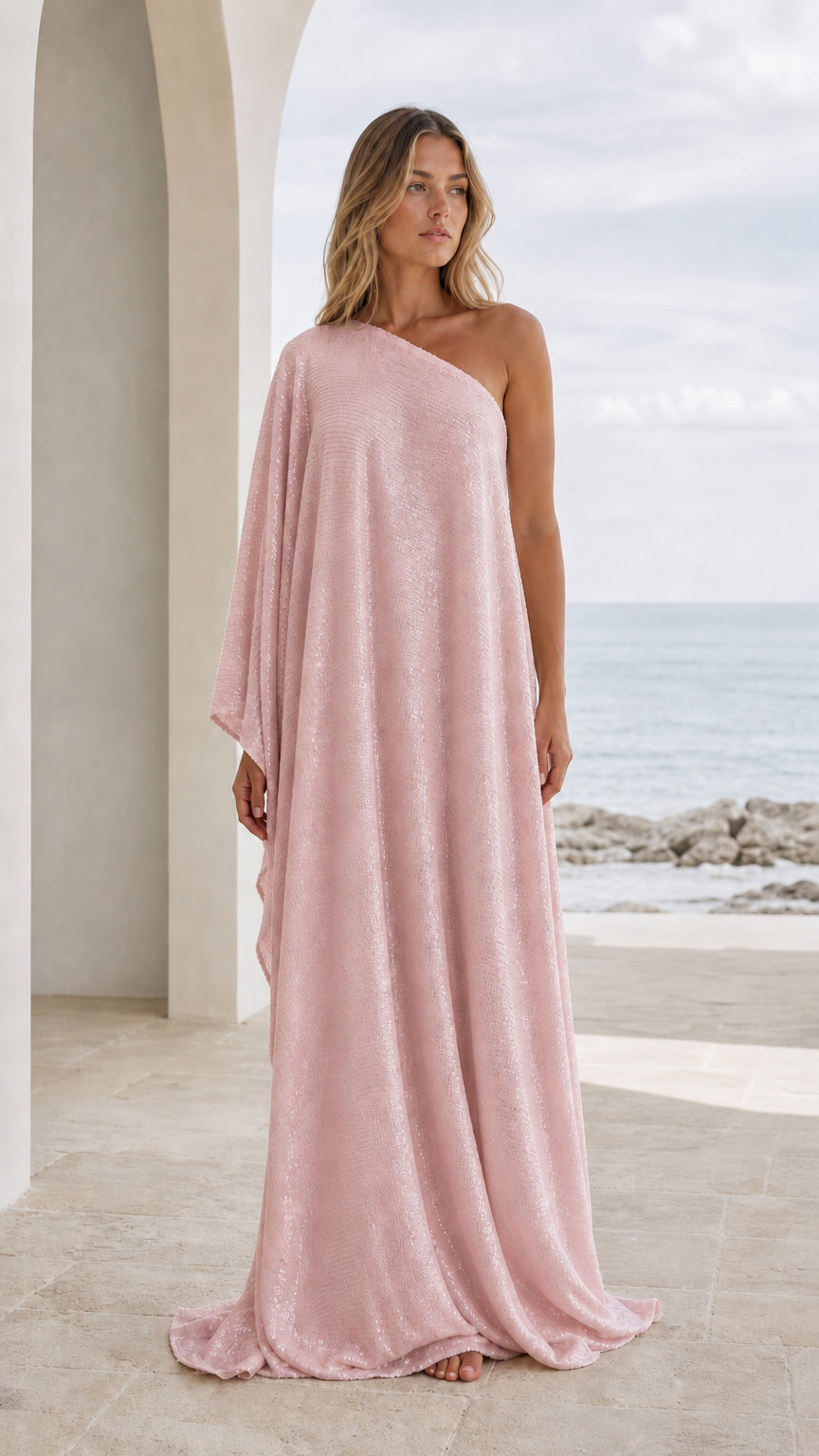 Front view of woman wearing pink one-shoulder draped maxi kaftan dress
