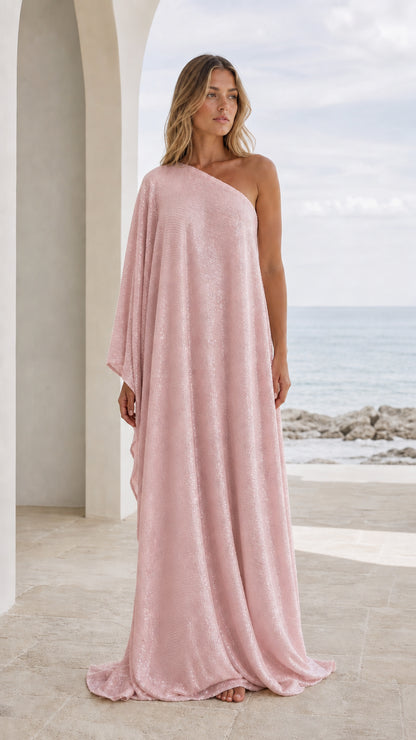 Front view of woman wearing pink one-shoulder draped maxi kaftan dress