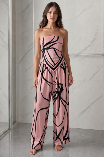 Woman wearing pink and black abstract print strapless jumpsuit