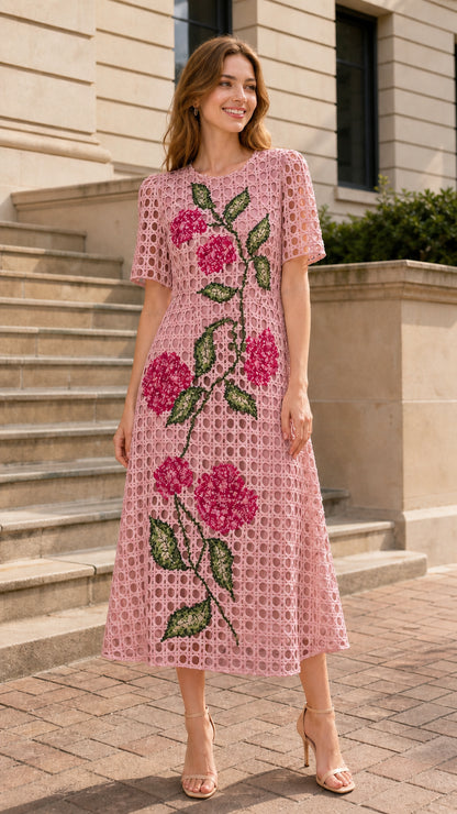 Front view of woman wearing pink floral embroidered midi dress