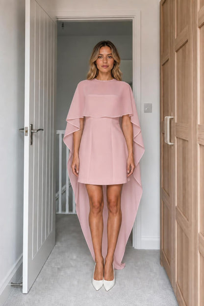 Model wearing pink cape-overlay high-low mini dress
