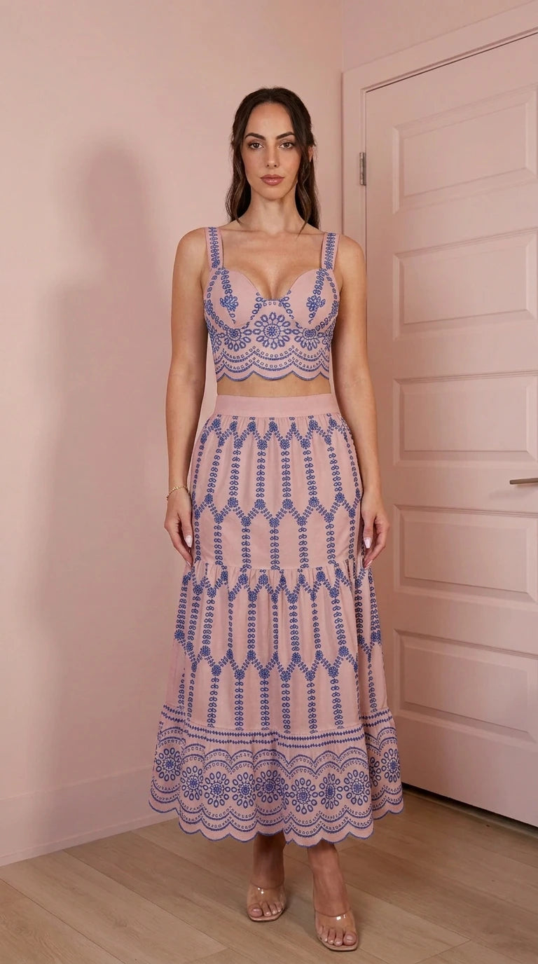 Model wearing pink two-piece embroidered crop top and skirt set