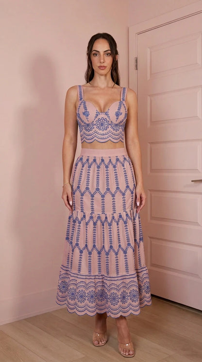 Model wearing pink two-piece embroidered crop top and skirt set