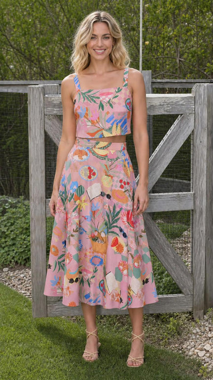 Model wearing pink-based printed crop top and skirt set