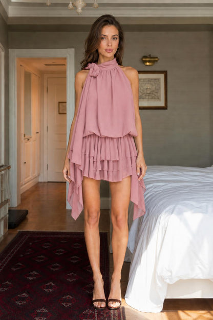 Woman wearing pink halter neck tiered mini dress front view