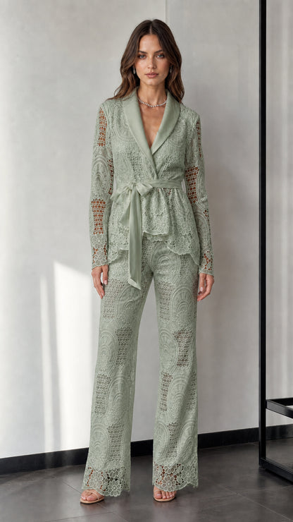 Woman wearing sage green lace blazer and trousers set