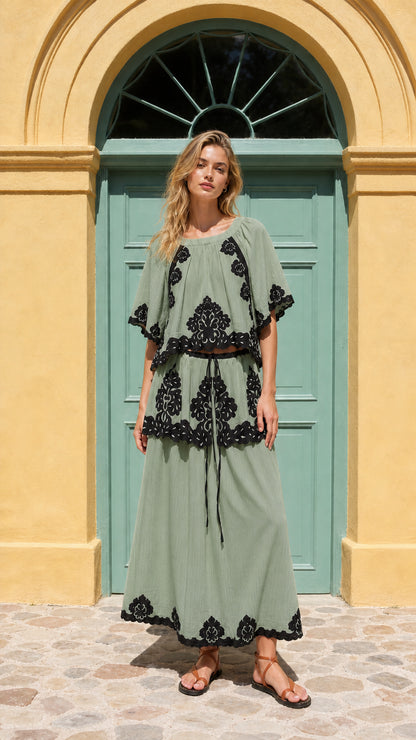 Front view of model wearing sage green two-piece embroidered maxi set