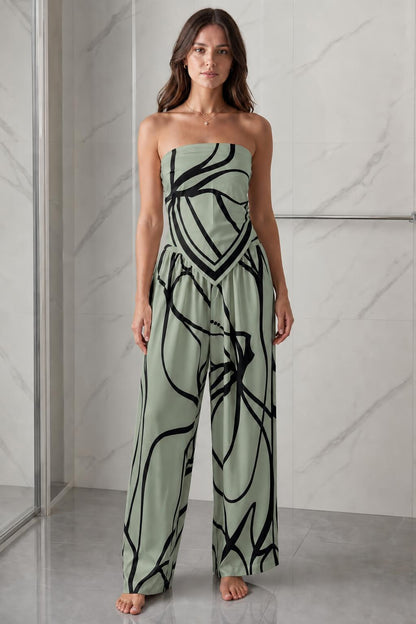 Woman wearing sage green and black abstract print strapless jumpsuit