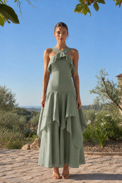 Front view of woman wearing sage green halter neck ruffled maxi dress