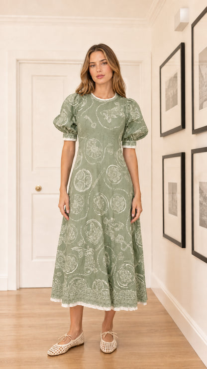 Woman wearing sage green embroidered puff sleeve midi dress