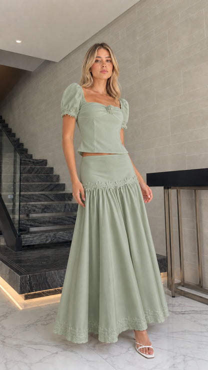 Model wearing sage green puff sleeve crop top and maxi skirt set
