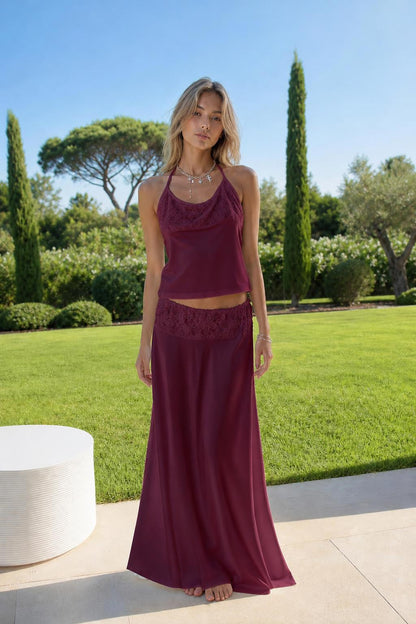 Model wearing burgundy satin halter top and lace skirt set