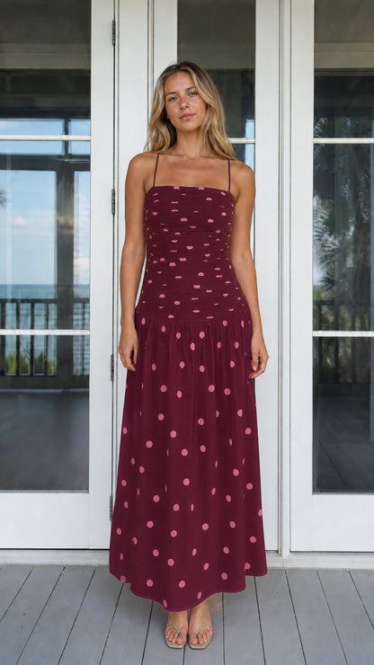 Model wearing burgundy polka dot smocked maxi dress