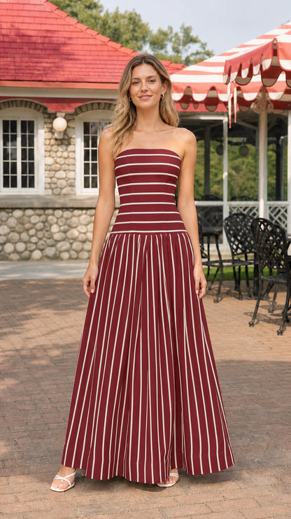 Model wearing burgundy and white striped strapless maxi dress