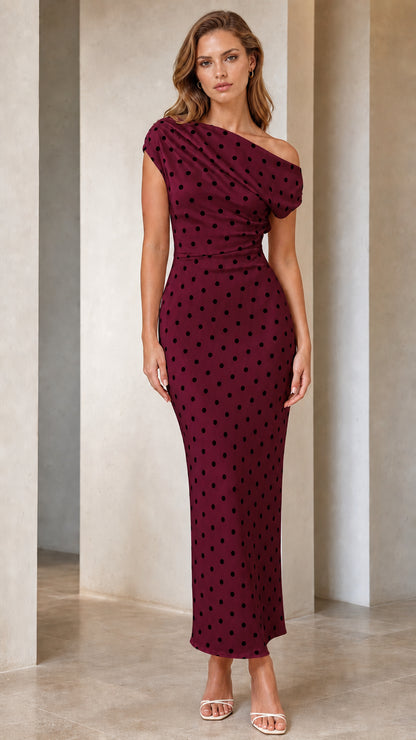 Front view of model wearing burgundy polka dot one-shoulder dress