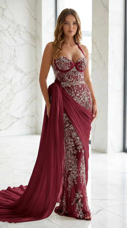 Model wearing deep burgundy beaded evening gown with matching burgundy drape