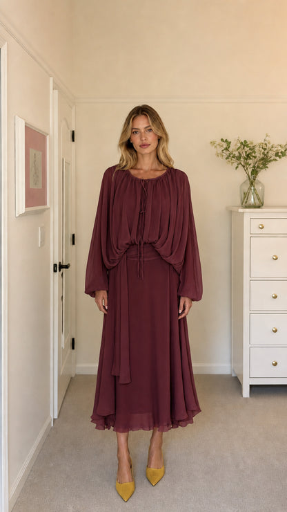 Model wearing burgundy long-sleeve pleated midi dress