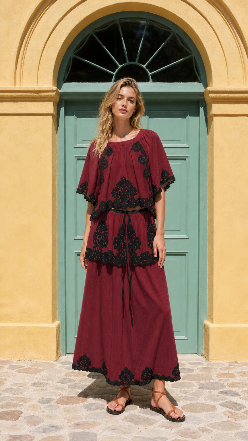 Front view of model wearing burgundy two-piece embroidered maxi set