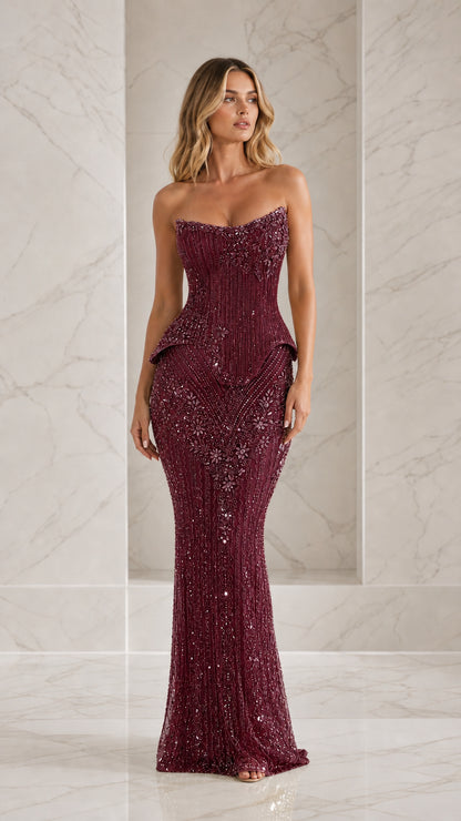 Front view of model wearing burgundy beaded strapless evening gown