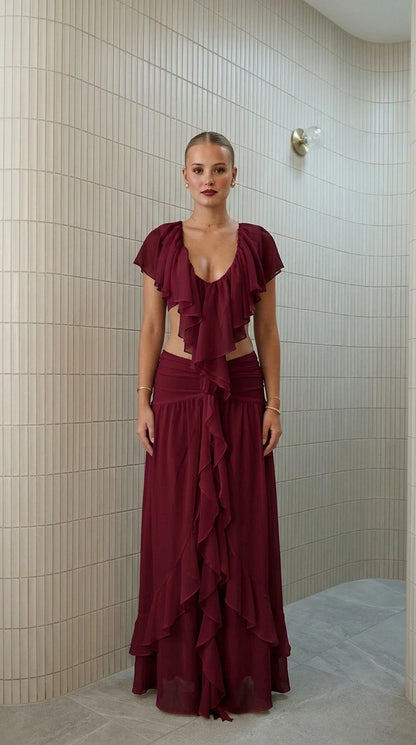 Front view of model wearing burgundy ruffled two-piece maxi set