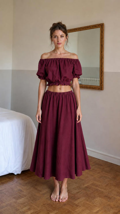 Front view of woman wearing burgundy off-shoulder crop top and midi skirt set