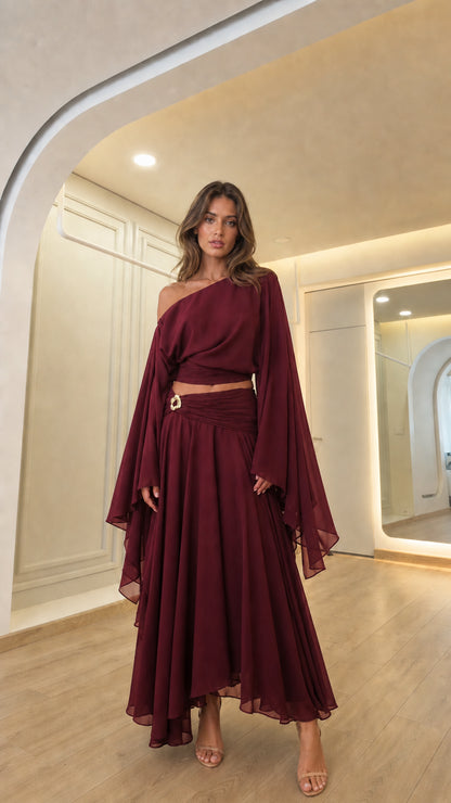 Woman wearing the burgundy color variant of the elegant evening set