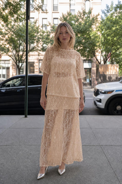 Woman wearing champagne sheer sequin lace two-piece set
