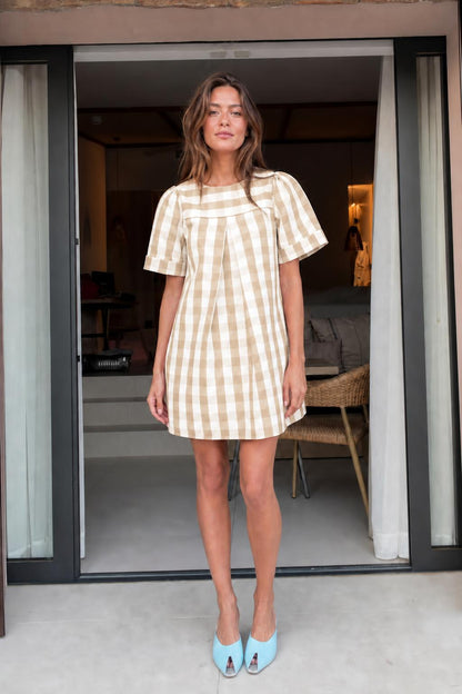 Front view of woman wearing khaki gingham check mini dress