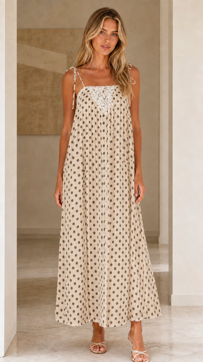 Front view of woman wearing beige polka dot maxi dress